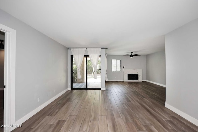 9355 N 91st St Unit 112, Scottsdale, AZ 85258 - unfurnished living room featuring dark wood-style flooring, a ceiling fan, baseboards, and a fireplace