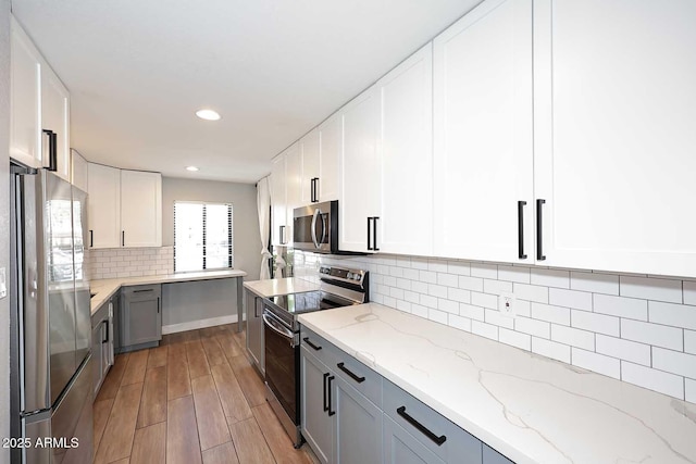 9355 N 91st St Unit 112, Scottsdale, AZ 85258 - kitchen featuring stainless steel appliances, light wood finished floors, backsplash, recessed lighting, and light stone counters