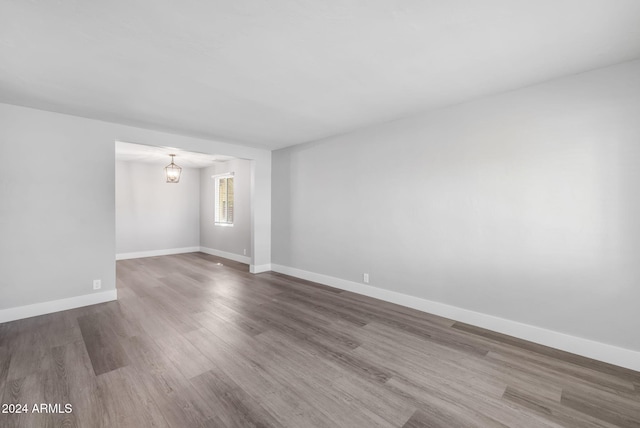 spare room with a chandelier and dark hardwood / wood-style flooring