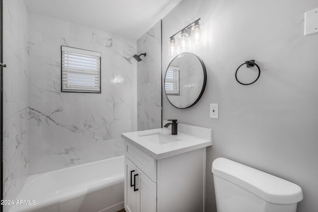 full bathroom featuring vanity, tiled shower / bath combo, and toilet