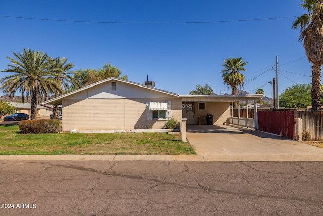 single story home with a front yard and a carport