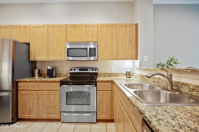 kitchen with light brown cabinetry, sink, light stone counters, light tile patterned floors, and appliances with stainless steel finishes