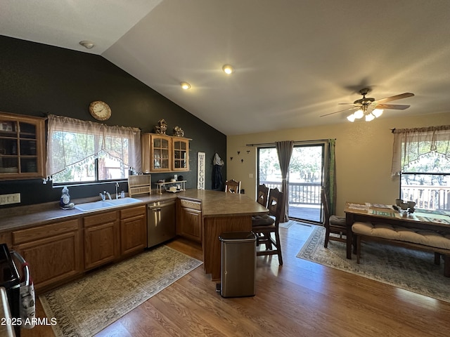kitchen featuring a peninsula, dishwasher, a sink, and plenty of natural light