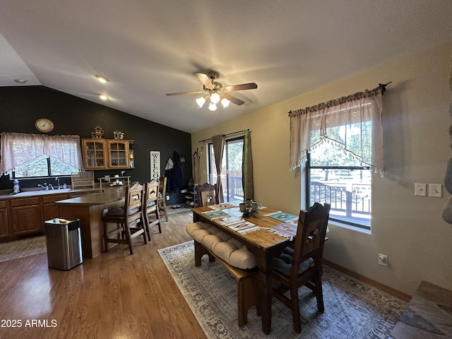 dining area featuring vaulted ceiling, wood finished floors, and ceiling fan
