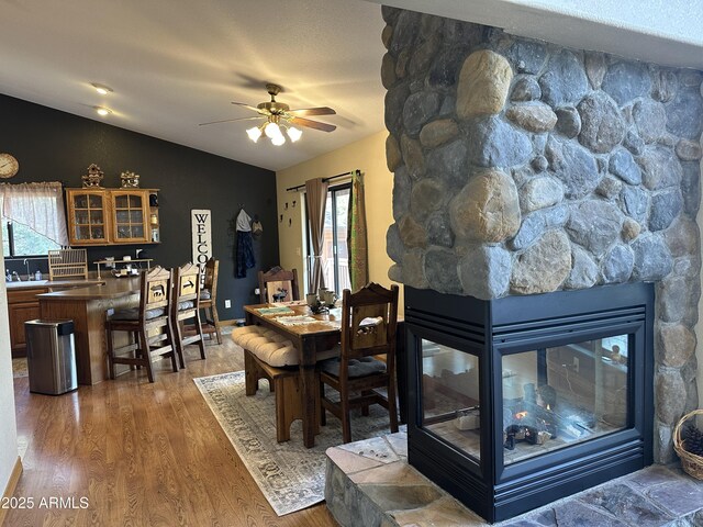 dining room with lofted ceiling, a ceiling fan, wood finished floors, and a healthy amount of sunlight