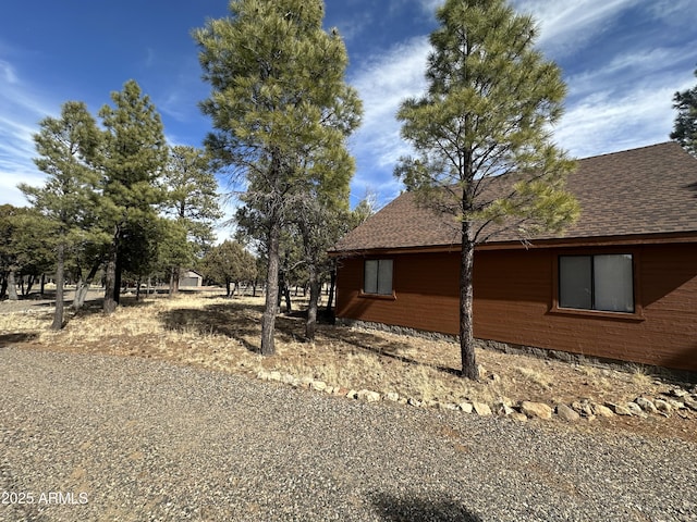 view of side of home featuring roof with shingles