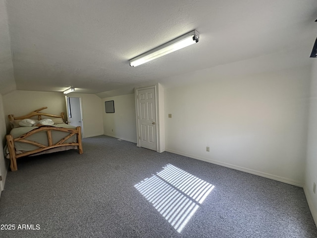 unfurnished bedroom with carpet floors, a textured ceiling, and baseboards