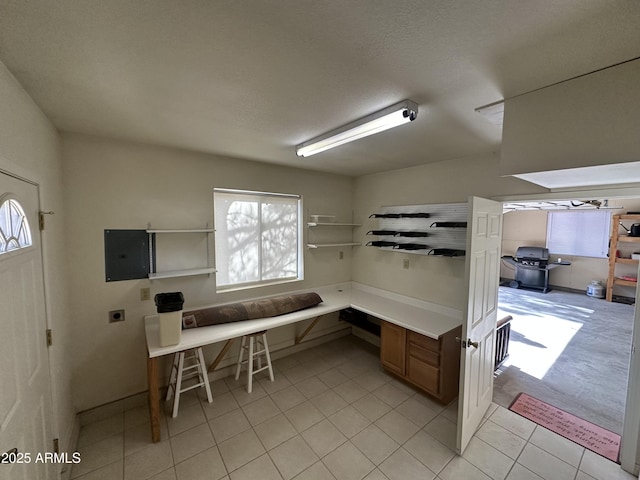 home office featuring light tile patterned floors, electric panel, and plenty of natural light