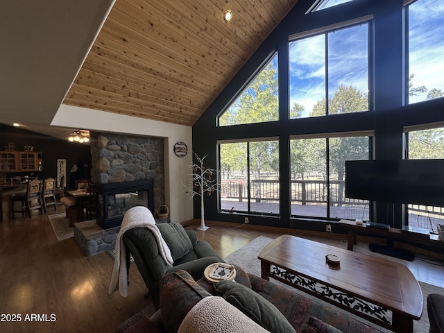 living area with wood ceiling, a fireplace, wood finished floors, and high vaulted ceiling