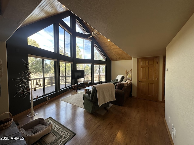 living room featuring wood finished floors, lofted ceiling, and baseboards