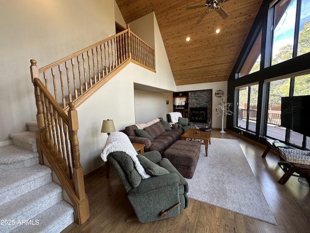 living room with baseboards, a ceiling fan, stairway, wood ceiling, and high vaulted ceiling