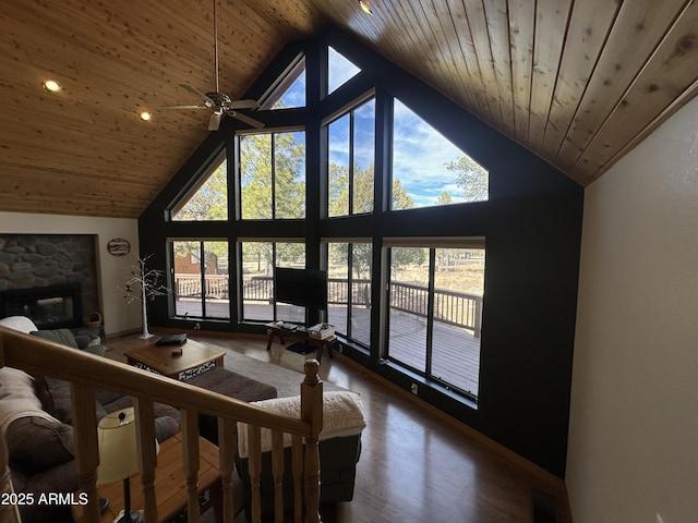 living area with high vaulted ceiling, wood ceiling, wood finished floors, and a fireplace