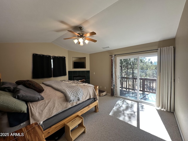 carpeted bedroom with vaulted ceiling, a tile fireplace, baseboards, access to outside, and visible vents