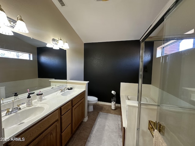 bathroom featuring a bath, vaulted ceiling, tile patterned flooring, and a sink