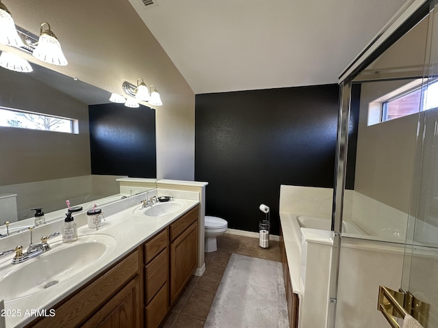 bathroom with a garden tub, vaulted ceiling, a sink, and toilet