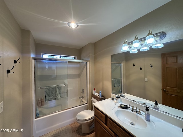 full bath with toilet, vanity, and shower / bath combination with glass door