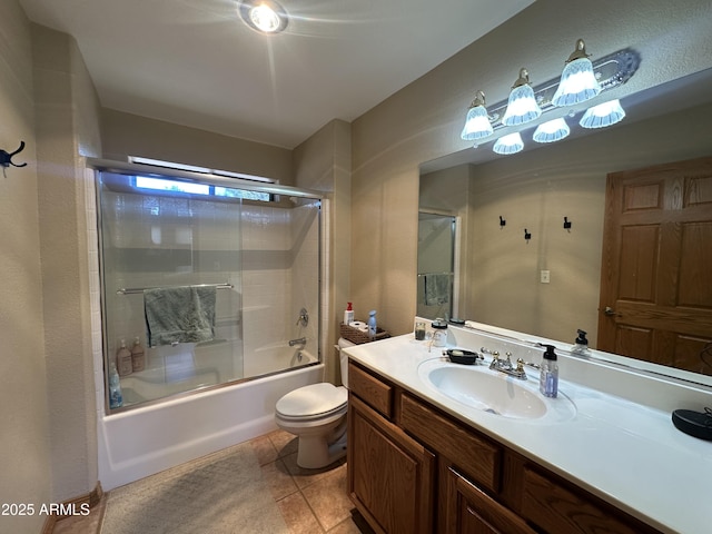 bathroom featuring enclosed tub / shower combo, tile patterned flooring, vanity, and toilet