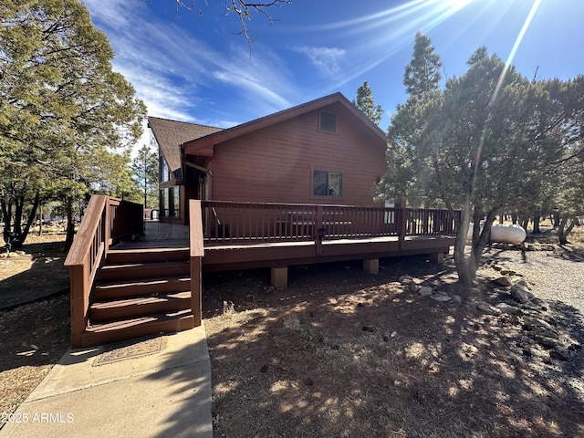 view of property exterior with a wooden deck