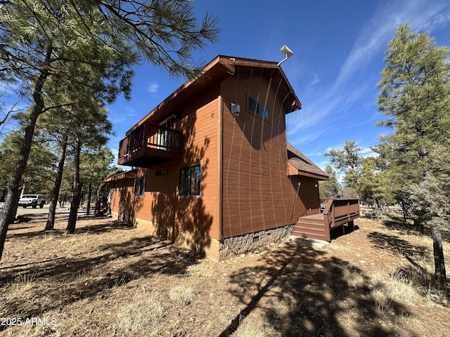 view of home's exterior with a balcony and a deck