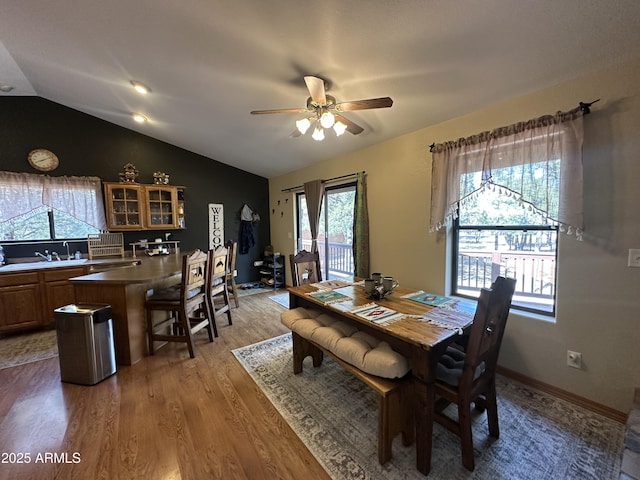dining room featuring lofted ceiling, a ceiling fan, and wood finished floors