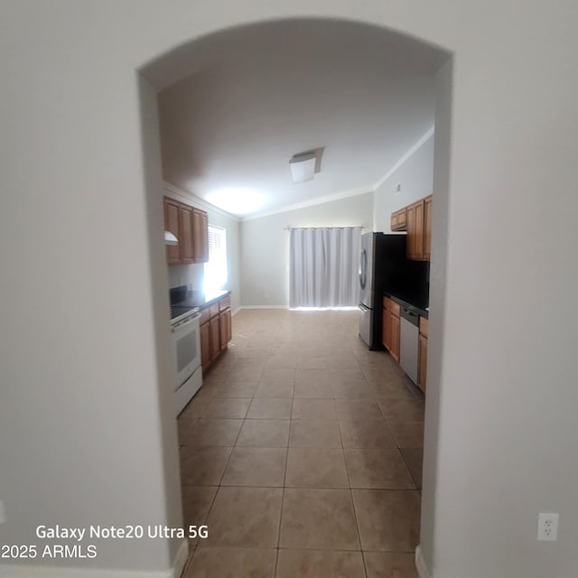 1829 E Adams St, Phoenix, AZ 85034 - kitchen featuring vaulted ceiling, ornamental molding, light tile patterned flooring, appliances with stainless steel finishes, and brown cabinets