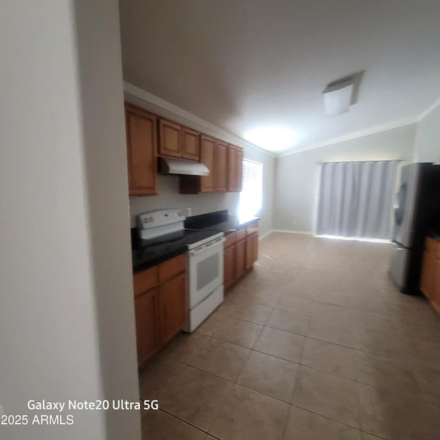 1829 E Adams St, Phoenix, AZ 85034 - kitchen with under cabinet range hood, white range with electric cooktop, light tile patterned flooring, dark countertops, and freestanding refrigerator