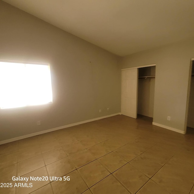 1829 E Adams St, Phoenix, AZ 85034 - unfurnished bedroom featuring light tile patterned flooring, baseboards, vaulted ceiling, and a closet