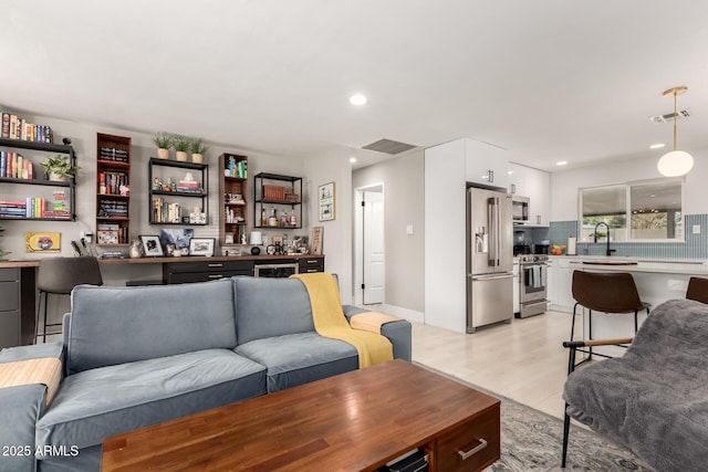 living room featuring wet bar and light wood-type flooring