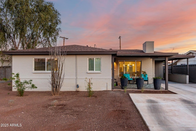 back house at dusk featuring a patio