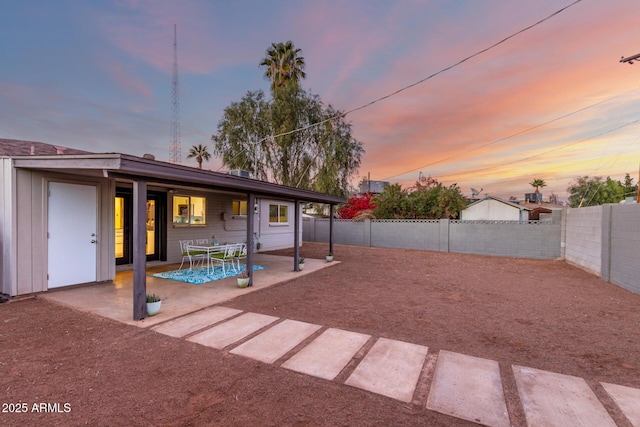 yard at dusk featuring a patio