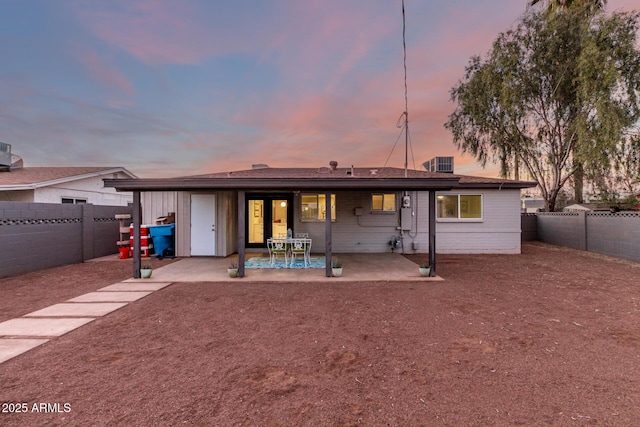 back house at dusk with a patio