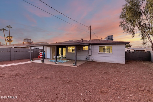 back house at dusk with a patio area