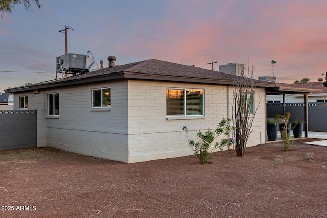 property exterior at dusk featuring central air condition unit