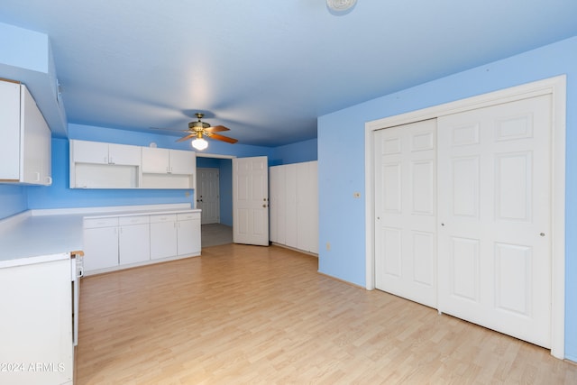 kitchen featuring white cabinets, light hardwood / wood-style flooring, and ceiling fan