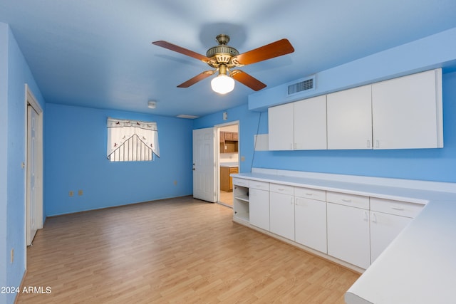 kitchen featuring white cabinets, ceiling fan, and light wood-type flooring