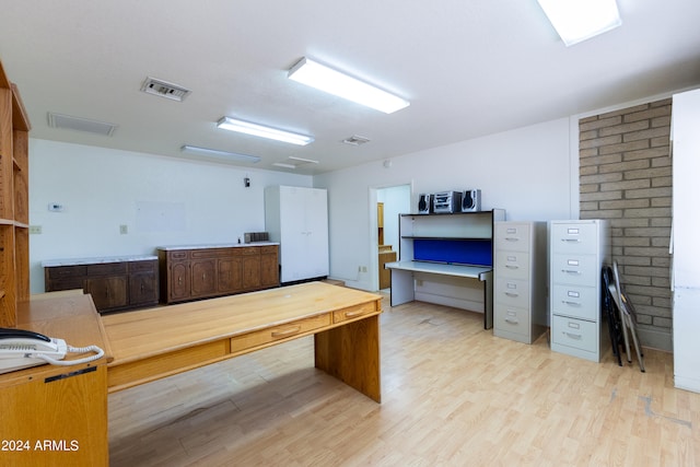 office space featuring brick wall and light wood-type flooring