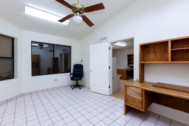 unfurnished office featuring lofted ceiling, ceiling fan, and light tile floors