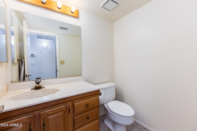 bathroom with vanity, toilet, and tile flooring