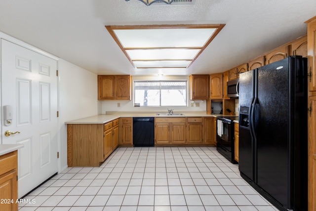 kitchen featuring black appliances, sink, and light tile flooring