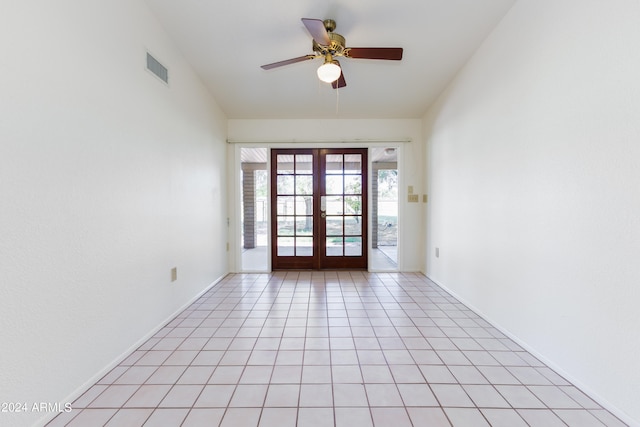 spare room featuring french doors, ceiling fan, and light tile floors