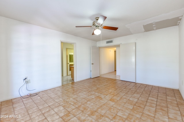 spare room featuring ceiling fan and light tile floors