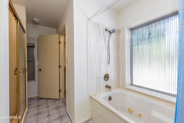 bathroom with plenty of natural light, tile floors, and a textured ceiling