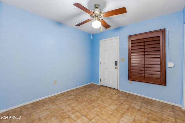 spare room featuring ceiling fan and light tile flooring