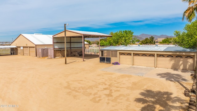 view of yard featuring a mountain view, an outdoor structure, and a garage