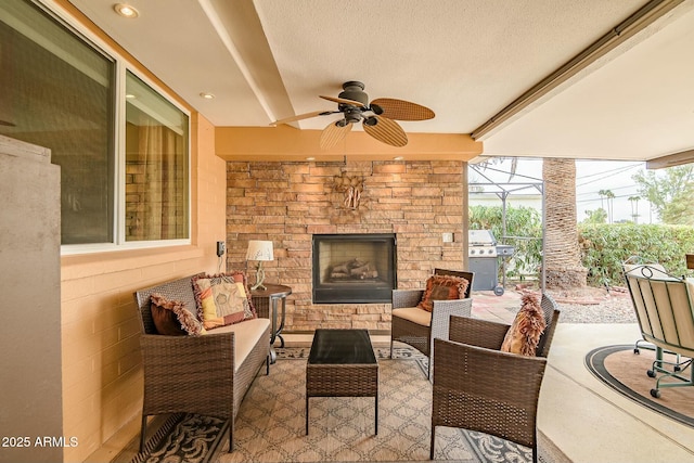 view of patio / terrace with a ceiling fan, a lanai, area for grilling, and an outdoor living space with a fireplace