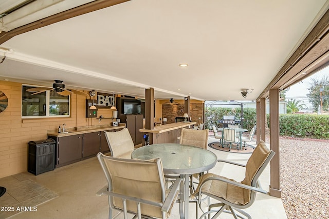 view of patio with outdoor dining space and a sink