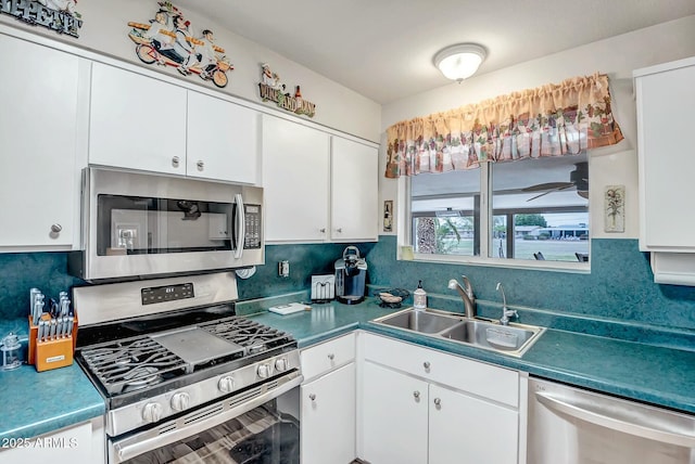 kitchen featuring white cabinets, decorative backsplash, stainless steel appliances, and a sink