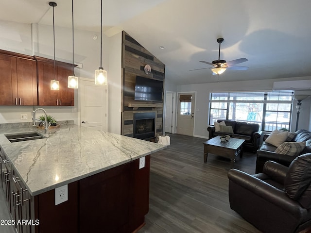 kitchen with dark wood finished floors, a tiled fireplace, open floor plan, a sink, and a wall mounted AC