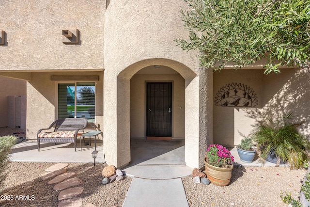 view of exterior entry with a patio