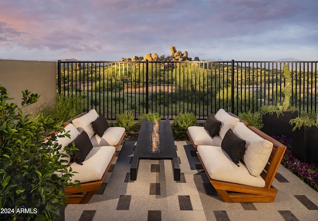patio terrace at dusk featuring fence and an outdoor hangout area